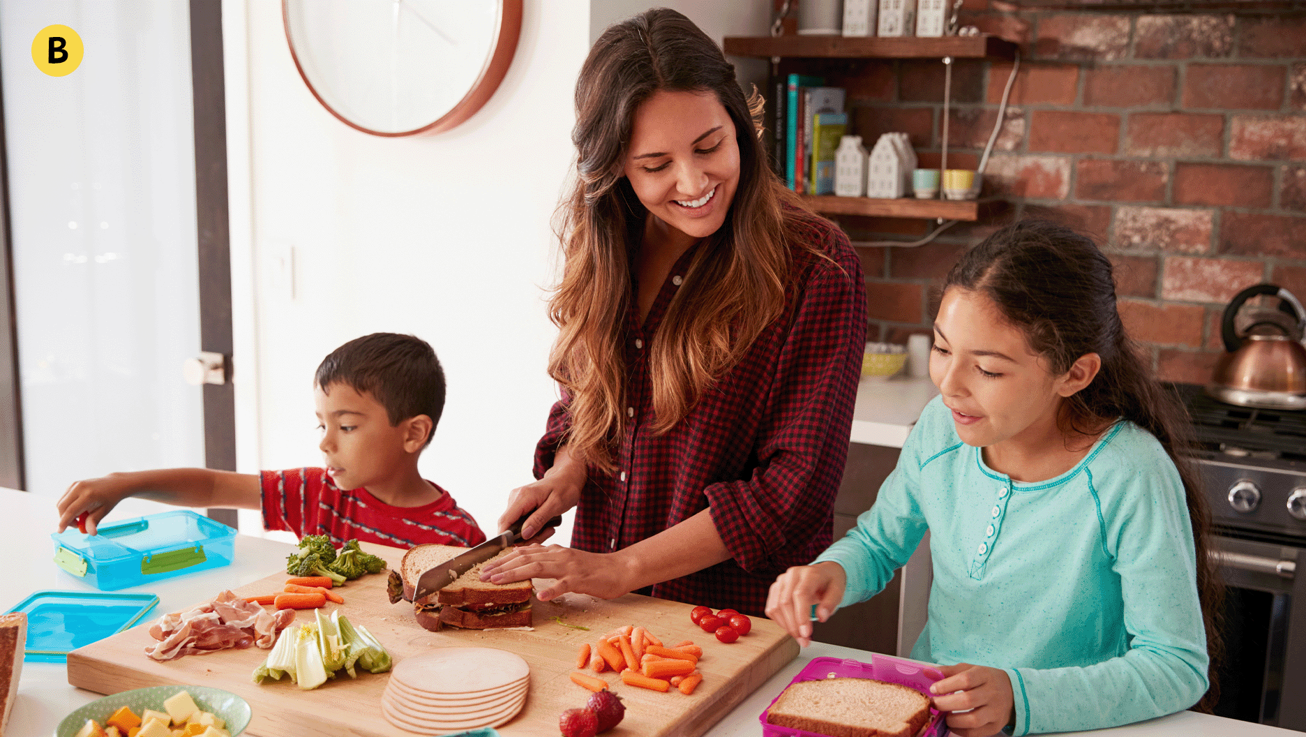 Deux jeunes font des sandwichs avec un parent dans la cuisine.