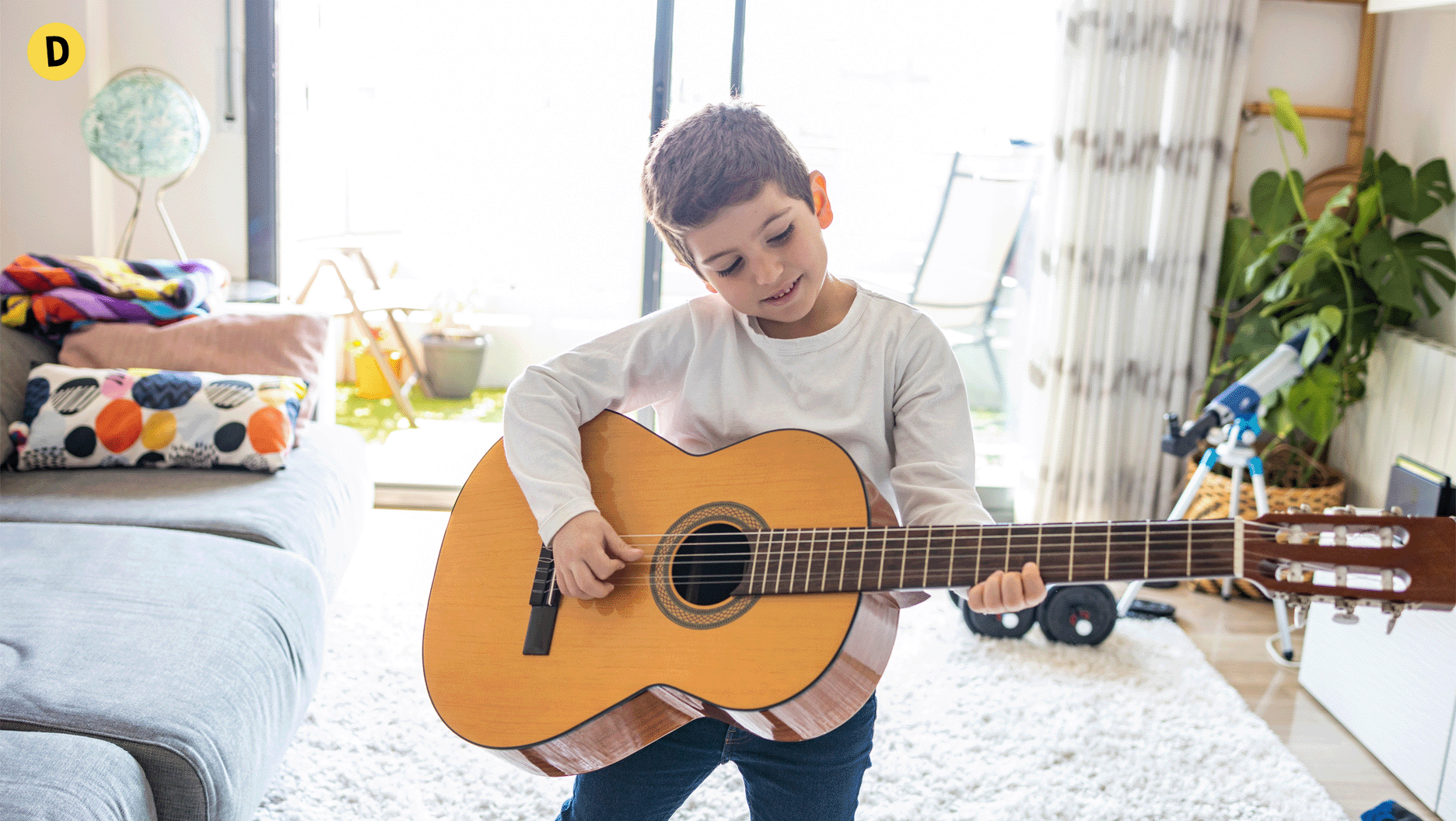 Un garçon qui joue de la guitare.