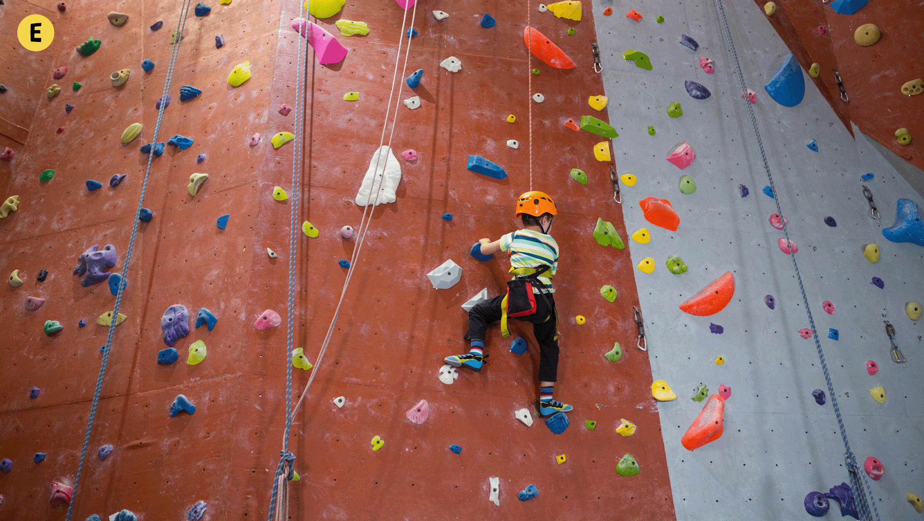 Un enfant qui grimpe à un mur d’escalade.