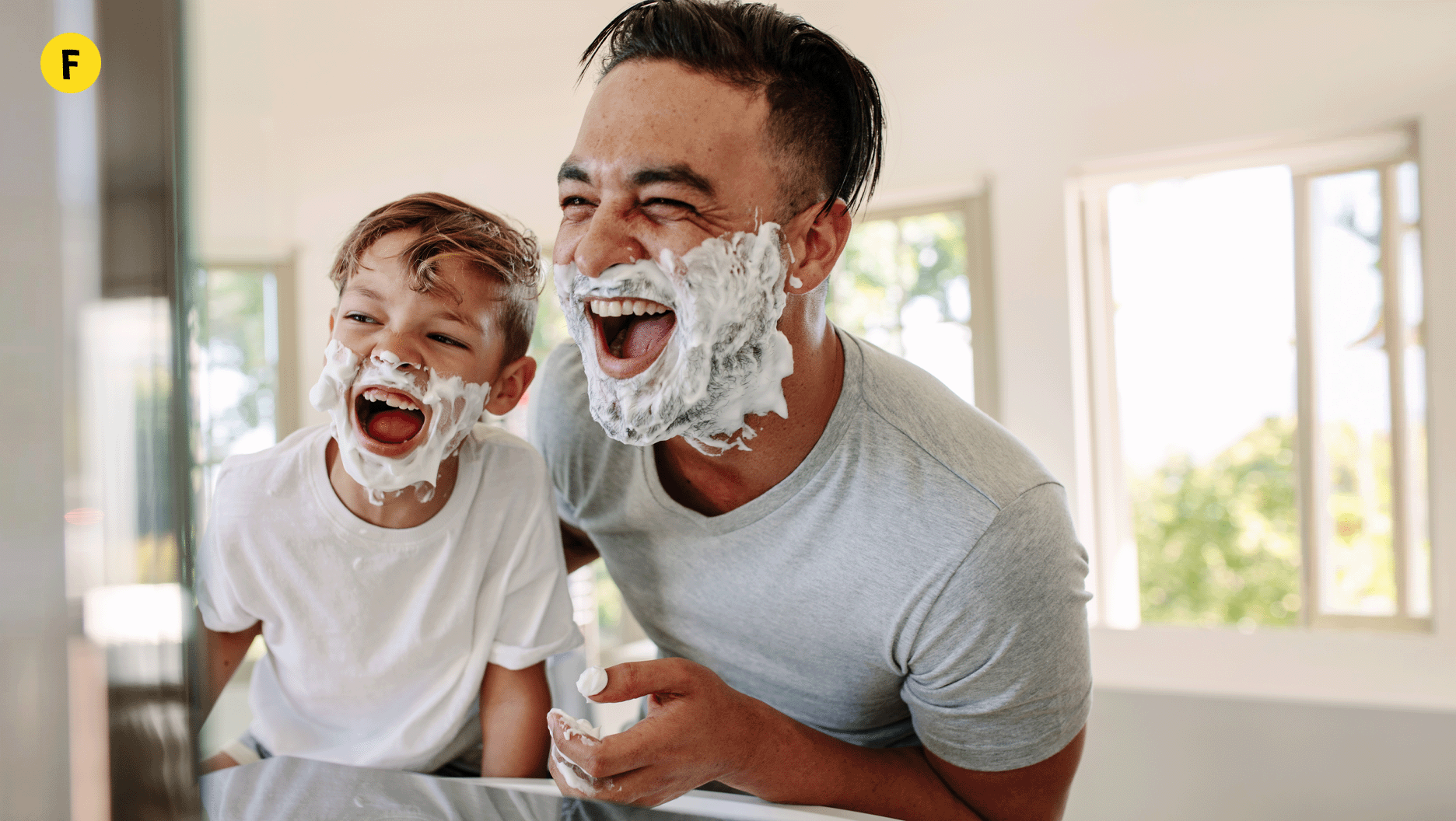 F. Un papa et son garçon rigolent en se mettant de la crème à raser sur le visage.
