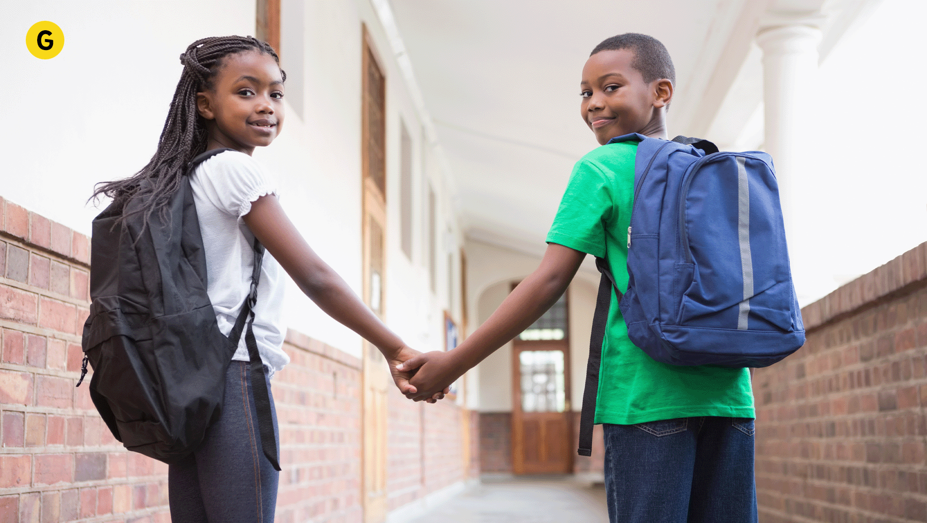 G. Deux jeunes se tiennent par la main à l'école.