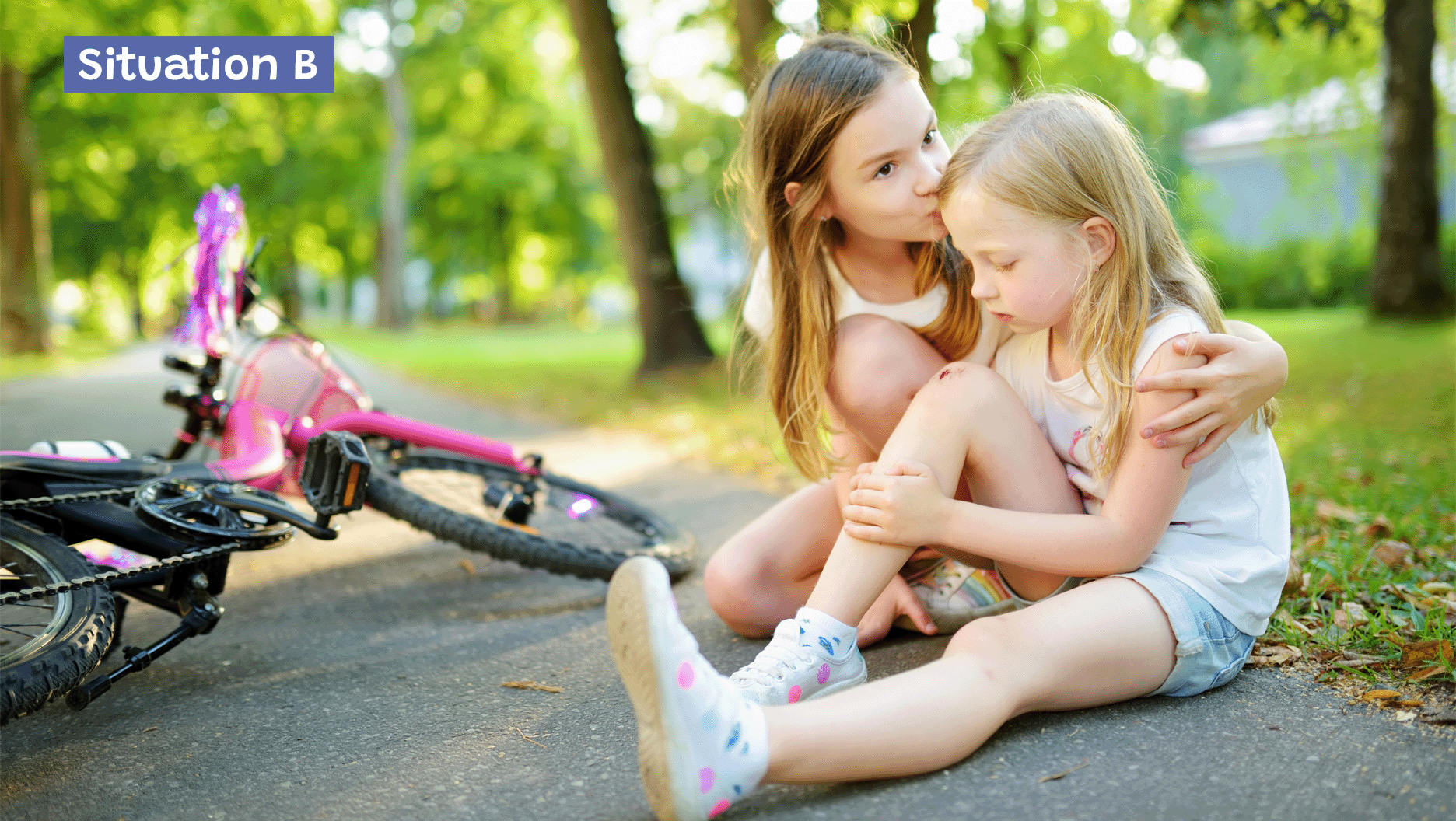 Situation B: Une fille qui console une amie tombée de sa bicyclette.