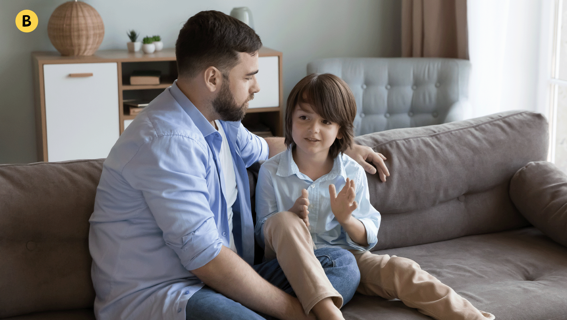 Un papa écoute attentivement son garçon qui lui parle.