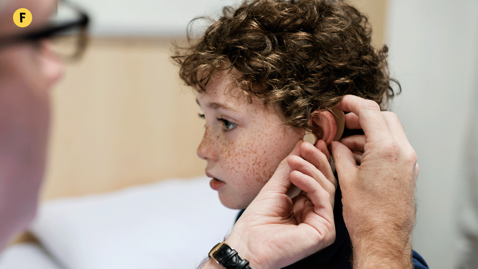 Un jeune garçon se fait installer un appareil auditif pour lui permettre de mieux entendre.
