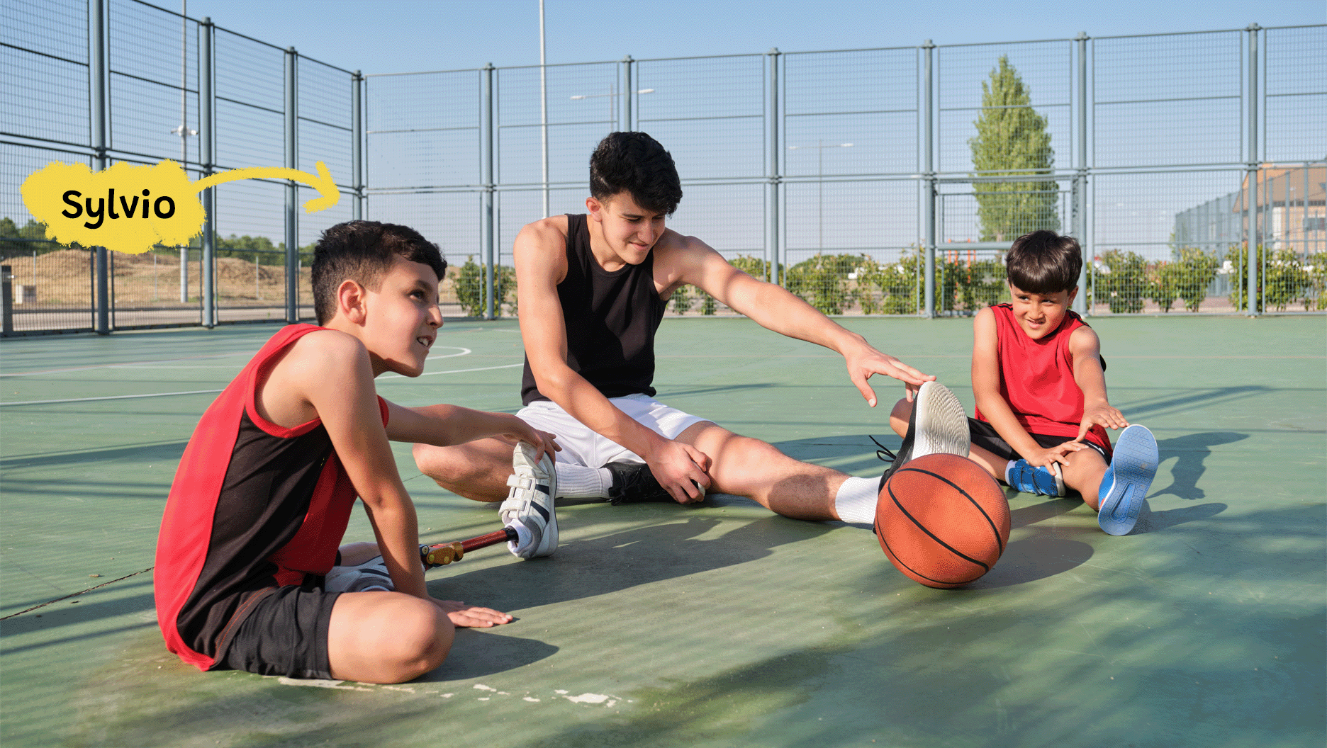 Sylvio fait des étirements avant de commencer une partie de basketball avec ses frères. Il porte une prothèse à la jambe gauche.