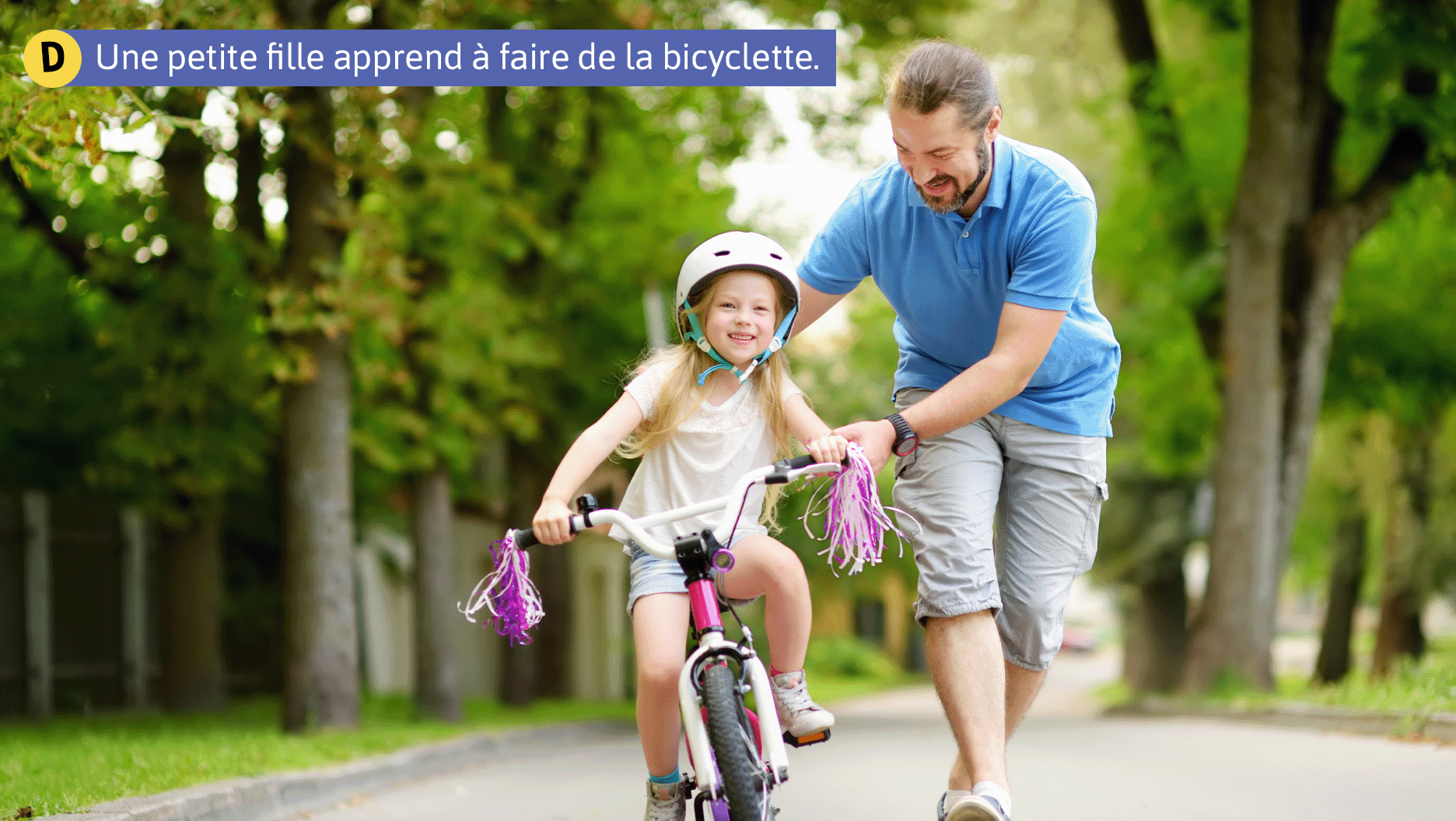 Une petite fille apprend à faire de la bicyclette.
