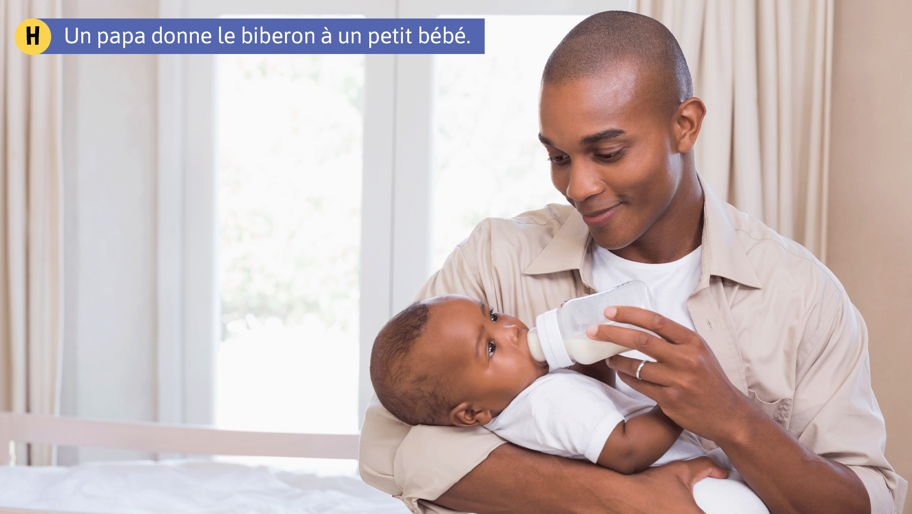 Un papa donne le biberon à un petit bébé.