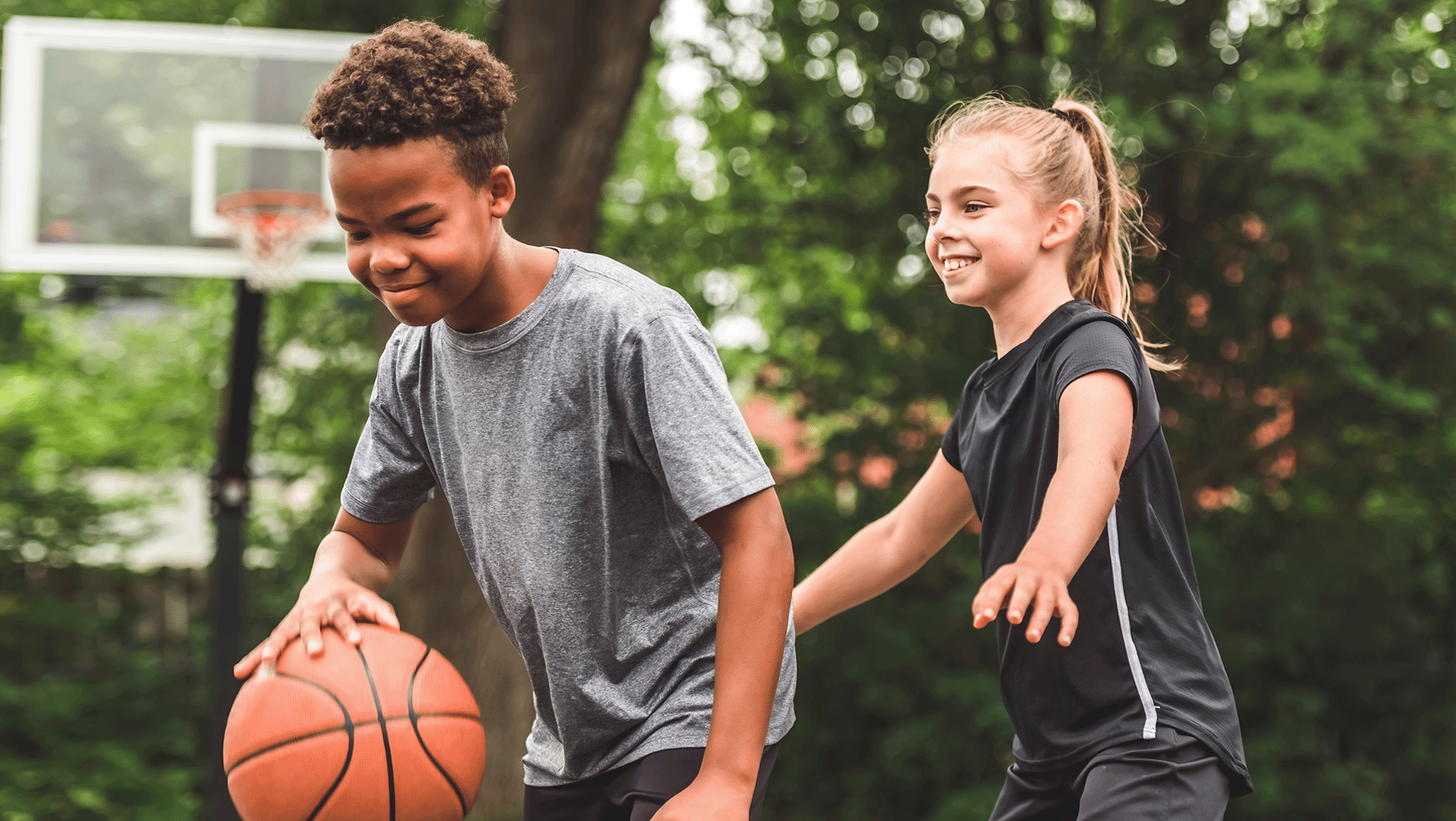 Un garçon et une fille jouent ensemble au basketball.