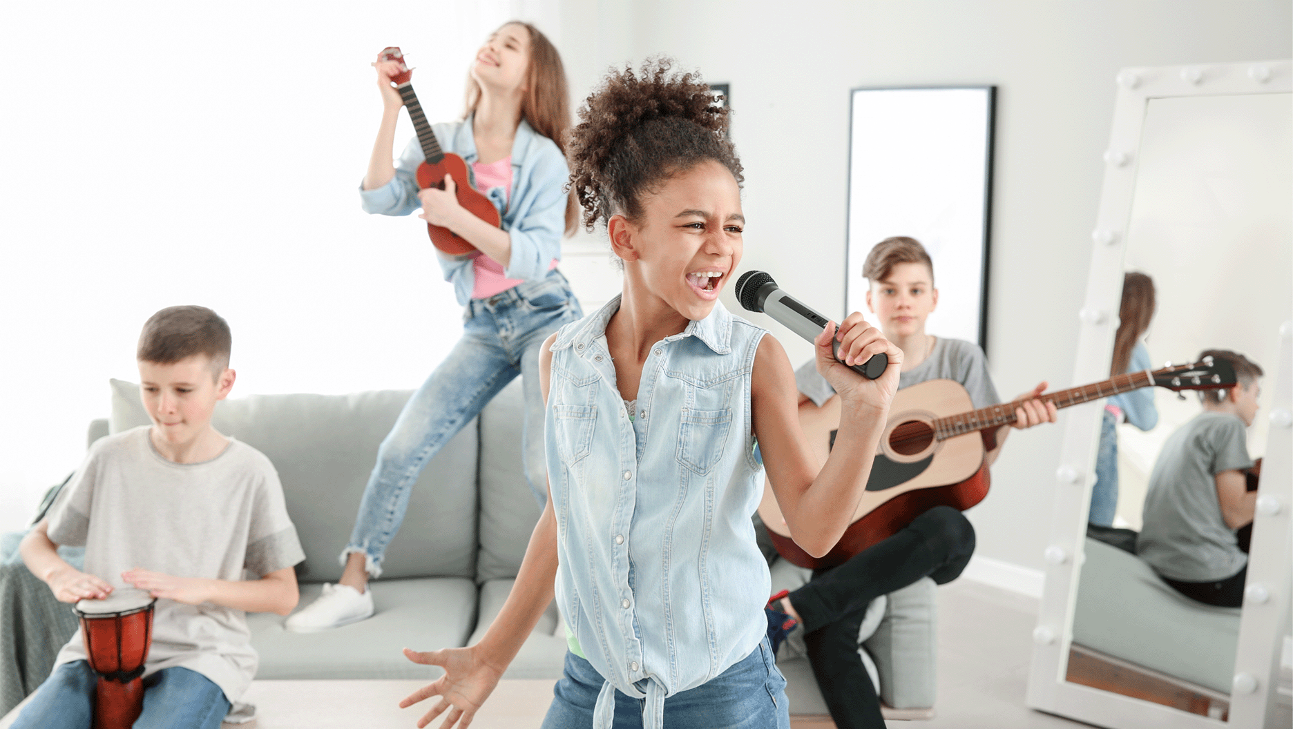 Quatre jeunes jouent de la musique et chantent dans le salon d’une amie.