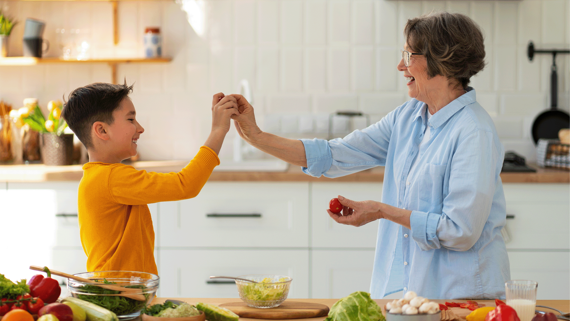 Un garçon et sa grand-mère ont du plaisir en cuisinant un repas.