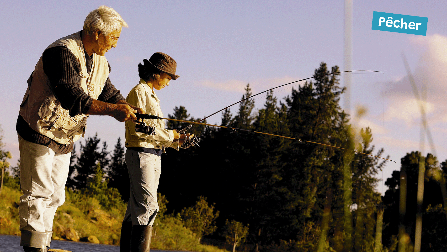 Un jeune et son grand-père pêchent au bout d’un quai.