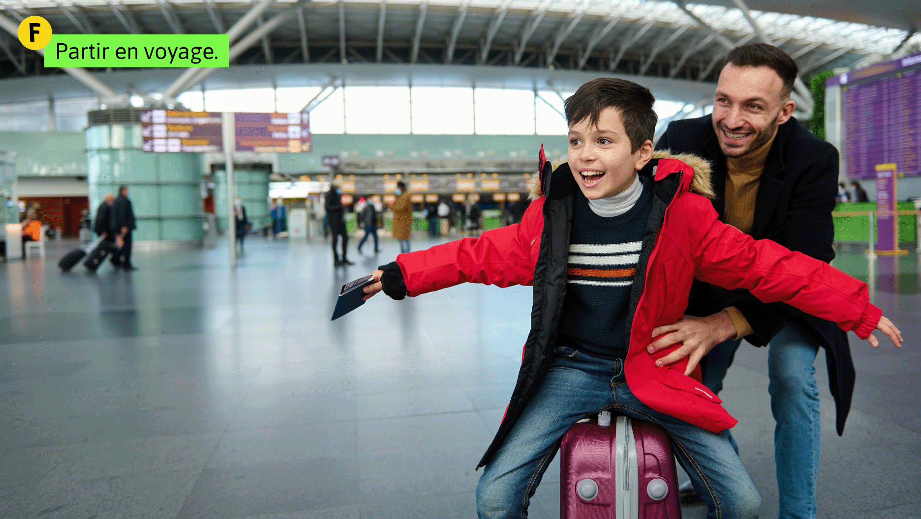 Situation F: Partir en voyage. Un garçon et son père s’amusent en attendant de prendre l’avion.