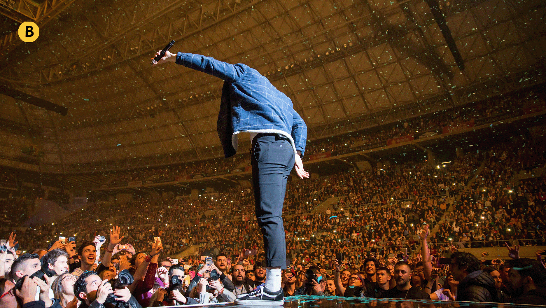 Un chanteur donne un spectacle devant une grande foule.